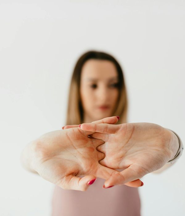 Woman performing a gentle stretching yoga pose in a calm studio.